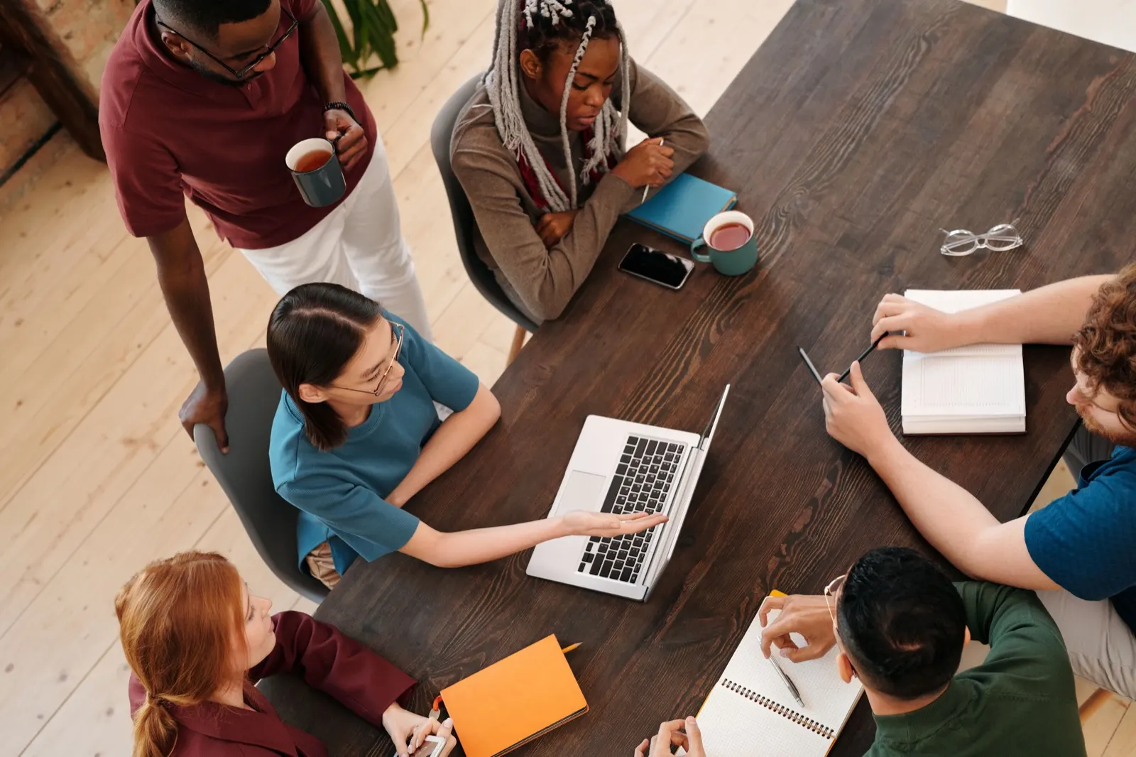 Grupo de personas estudiando alrededor de una mesa con un portátil
