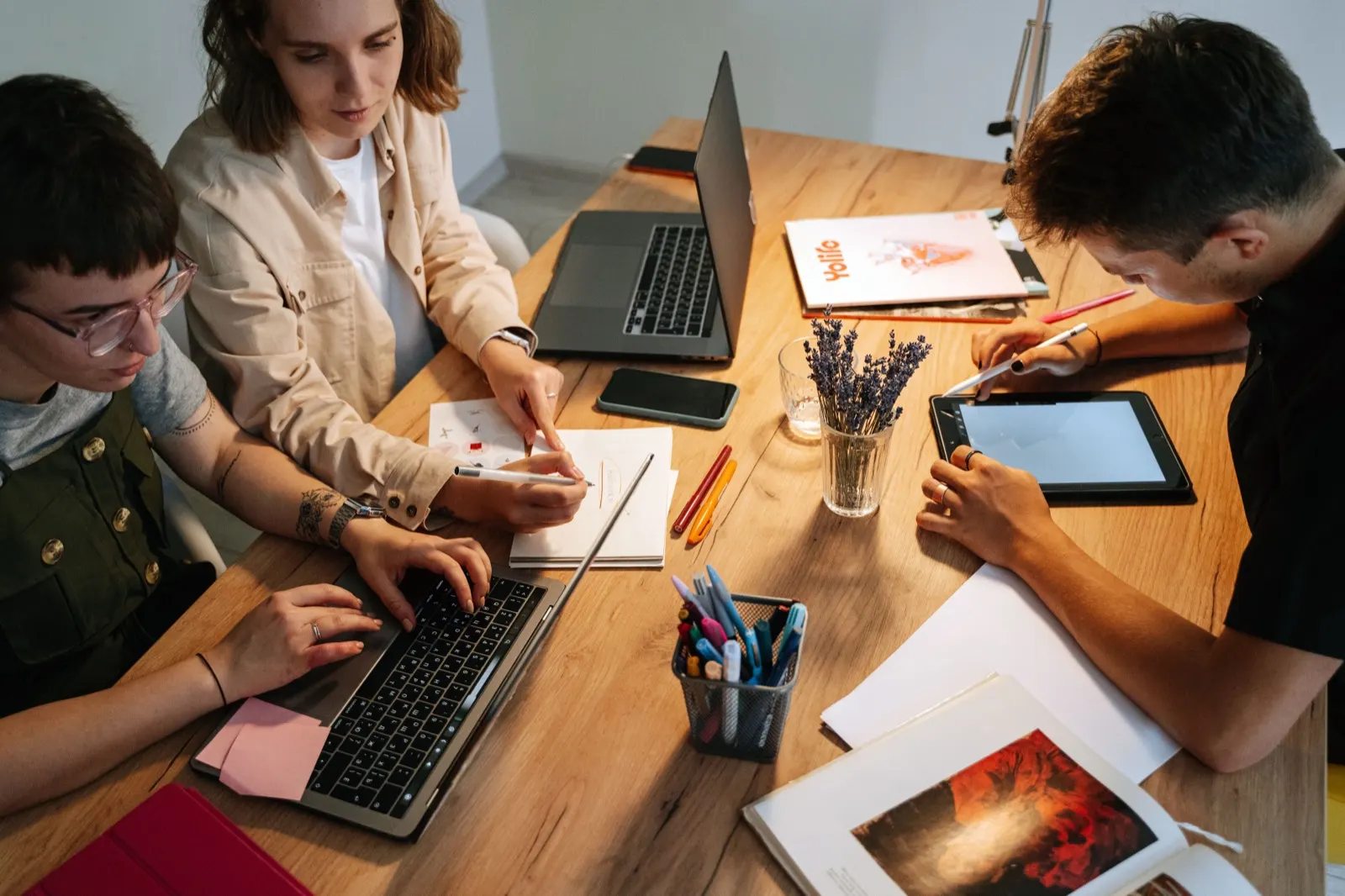 Grupo estudiando con portátiles y tabletas en una mesa de madera